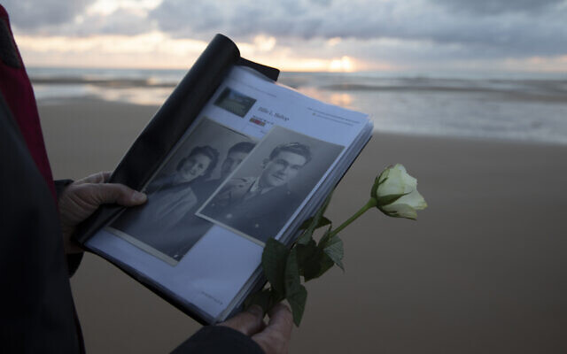 Billie Bishop, from San Jose, California, holds a photo of his uncle, WWII soldier Billie Bishop, as he prepares to lay a rose in the sea during a D-Day 76th anniversary ceremony in Saint Laurent sur Mer, Normandy, France, June 6, 2020 (AP Photo/Virginia Mayo) Billie Bishop, from San Jose, California, holds a photo of his uncle, WWII soldier Billie Bishop, as he prepares to lay a rose in the sea during a D-Day 76th anniversary ceremony in Saint Laurent sur Mer, Normandy, France, June 6, 2020 (AP Photo/Virginia Mayo)