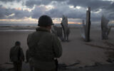 Two men in vintage US WWII uniforms walk toward the Les Braves monument at sunrise prior to a D-Day 76th anniversary ceremony in Saint Laurent sur Mer, Normandy, France, June 6, 2020 (AP Photo/Virginia Mayo)