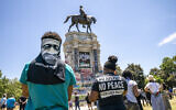 People gather at the Robert E. Lee Monument, now covered by protest graffiti, in Richmond, Virginia, June 7, 2020, following a week of unrest in the US against police brutality and racism in policing (AP Photo/J. Scott Applewhite)