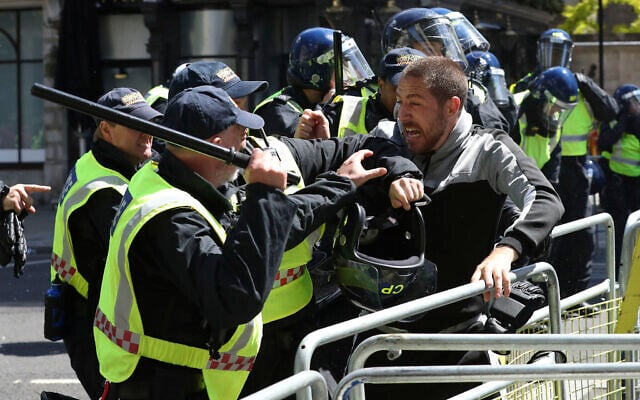 Police apprehend a protester in Whitehall near Parliament Square, London, during a protest by the Democratic Football Lads Alliance against a Black Lives Matter protest, Saturday June 13, 2020. (Jonathan Brady/PA via AP) Police apprehend a protester in Whitehall near Parliament Square, London, during a protest by the Democratic Football Lads Alliance against a Black Lives Matter protest, Saturday June 13, 2020. (Jonathan Brady/PA via AP)