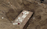 The remains of Nolberto Albina, who family members say died of COVID-19-related complications, are buried at the Martires 19 de Julio cemetery on the outskirts of Lima, Peru, June 17, 2020.  (AP Photo/Martin Mejia)