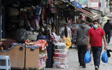 Shoppers walk past opened retail shops as coronavirus restrictions on non-essential retailers were lifted in London, Friday, June 19, 2020. (AP Photo/Frank Augstein)