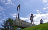 People look and photograph the new statue of American writer Jerome David Salinger in Paminklas, Lithuania, June 19, 2020. (AP Photo/Vladas Sciavinskas)