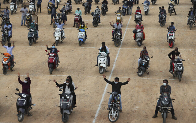 Faithful sit on their two-wheelers and pray as they attend a drive-in mass in an open area of Bethel AG Church as part of maintaining social distancing to prevent the spread of coronavirus in Bengaluru, India, Sunday, June 21, 2020. (AP Photo/Aijaz Rahi) Faithful sit on their two-wheelers and pray as they attend a drive-in mass in an open area of Bethel AG Church as part of maintaining social distancing to prevent the spread of coronavirus in Bengaluru, India, Sunday, June 21, 2020. (AP Photo/Aijaz Rahi)