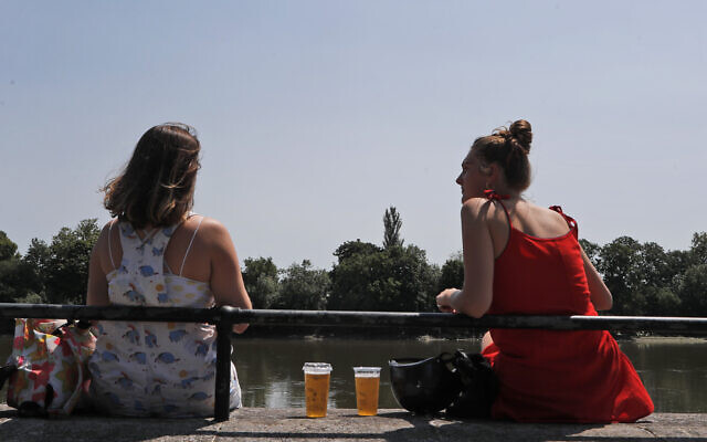 Two women sit with take away drinks from a pub on the banks of the river Thames in London, Tuesday, June 23, 2020. (AP/Frank Augstein) Two women sit with take away drinks from a pub on the banks of the river Thames in London, Tuesday, June 23, 2020. (AP/Frank Augstein)