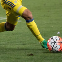 A Maccabi Tel Aviv player kicks a ball during a match (Yonatan Sindel/Flash90)