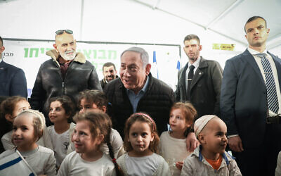 Prime Minister Benjamin Netanyahu poses with children during a tree planting event for the Jewish holiday of Tu Bishvat, in the West Bank settlement of Mevo'ot Yericho on February 10, 2020. (Flash90)