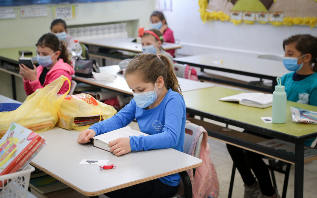 Illustrative: Elementary school students  at the Orot Etzion school in Efrat wear protective face masks when they return to school on May 3, 2020, for the first time since the outbreak of the coronavirus. (Gershon Elinon/Flash90)