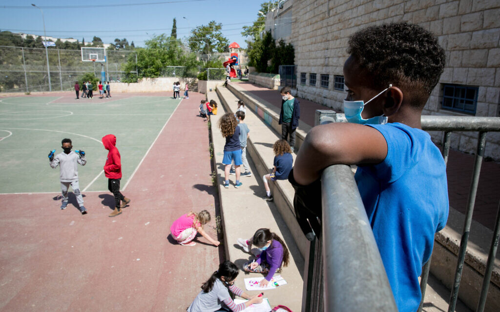 Illustrative: Israeli students when they returned to school for the first time since the outbreak in early May, wearing face masks, showing signed medical notes and keeping social distance (Courtesy Olivier Fitoussi/Flash90)