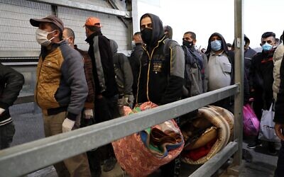 Palestinian workers enter Israel through the Mitar checkpoint in the West Bank city of Hebron, on May 3, 2020. (Wisam Hashlamoun/Flash90)
