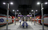 A man walks by trains at Yitzhak Navon station in Jerusalem on May 14, 2020 (Olivier Fitoussi/Flash90)