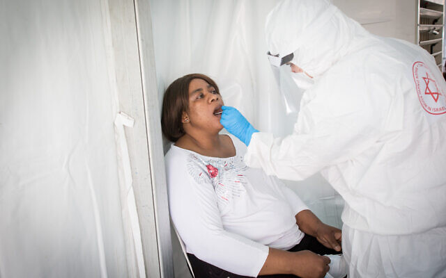 Magen David Adom medical workers test residents of South Tel Aviv at a temporary built site to collect samples for coronavirus, on June 2, 2020. (Miriam Alster/Flash90) Magen David Adom medical workers test residents of South Tel Aviv at a temporary built site to collect samples for coronavirus, on June 2, 2020. (Miriam Alster/Flash90)