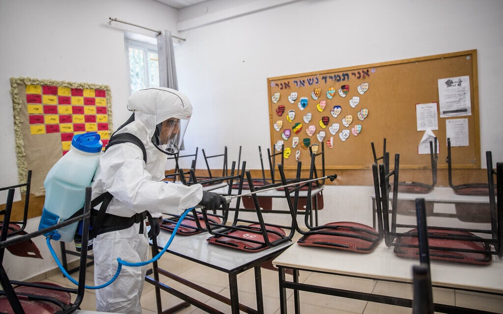 A cleaning worker disinfects a classroom in Jerusalem on June 3, 2020. (Yonatan Sindel/Flash90) A cleaning worker disinfects a classroom in Jerusalem on June 3, 2020. (Yonatan Sindel/Flash90)