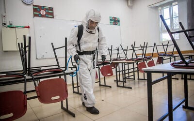 Cleaning workers disinfect a classroom at the Gymnasia Rehavia high school in Jerusalem on June 3, 2020. (Yonatan Sindel/Flash90)