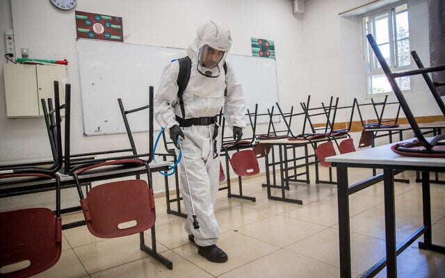 Cleaning workers disinfect a classroom at the Gymnasia Rehavia high school in Jerusalem on June 3, 2020. (Yonatan Sindel/Flash90) Cleaning workers disinfect a classroom at the Gymnasia Rehavia high school in Jerusalem on June 3, 2020. (Yonatan Sindel/Flash90)
