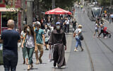 People wearing face masks walk in Jerusalem on June 8, 2020. (Olivier Fitoussi/ Flash90)