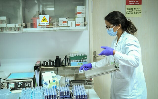 Technicians carry out a diagnostic test for coronavirus in a lab at Clalit Health Services branch in Tel Aviv, on June 9, 2020. (Yossi Zeliger/Flash90) Technicians carry out a diagnostic test for coronavirus in a lab at Clalit Health Services branch in Tel Aviv, on June 9, 2020. (Yossi Zeliger/Flash90)