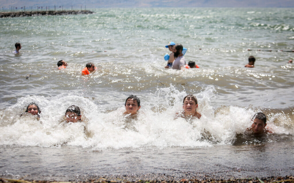 Israelis swim in the Sea of Galilee on June 12, 2020. (David Cohen/FLASH90 *** Local Caption) Israelis swim in the Sea of Galilee on June 12, 2020. (David Cohen/FLASH90 *** Local Caption)