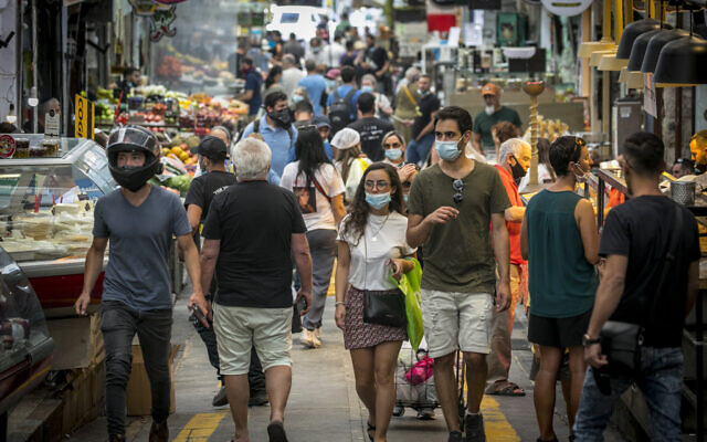 Illustrative: Israelis, wearing facemasks for fear of the coronavirus, shop for groceries at the Mahane Yehuda market in Jerusalem after it reopened according to the new government orders, June 16, 2020. (Olivier Fitoussi/Flash90) Illustrative: Israelis, wearing facemasks for fear of the coronavirus, shop for groceries at the Mahane Yehuda market in Jerusalem after it reopened according to the new government orders, June 16, 2020. (Olivier Fitoussi/Flash90)