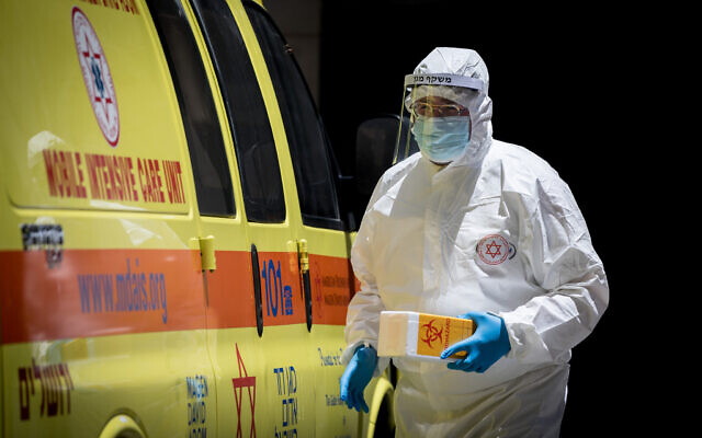 A Magen David Adom worker arrives to test a patient with symptoms of coronavirus in Jerusalem on June 23, 2020 (Yonatan Sindel/Flash90) A Magen David Adom worker arrives to test a patient with symptoms of coronavirus in Jerusalem on June 23, 2020 (Yonatan Sindel/Flash90)