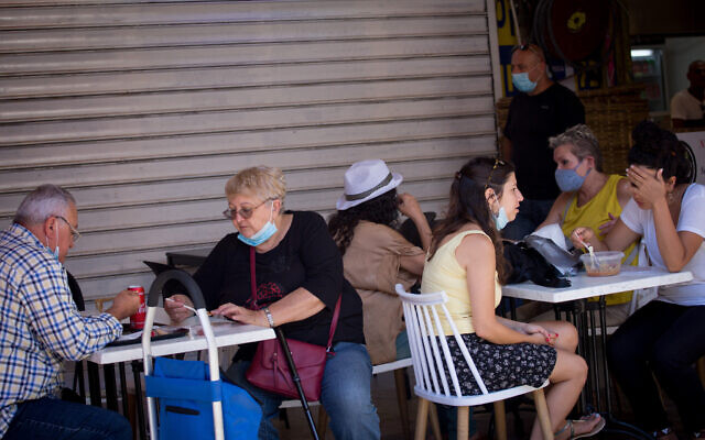 Israelis, some wearing protective face masks, in Tel Aviv on June 24, 2020. (Miriam Alster/Flash90) Israelis, some wearing protective face masks, in Tel Aviv on June 24, 2020. (Miriam Alster/Flash90)