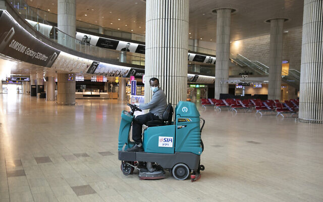 An airport staff cleaner in the empty arrivals hall at Ben Gurion International Airport on June 12, 2020 (Olivier Fitoussi/Flash90) An airport staff cleaner in the empty arrivals hall at Ben Gurion International Airport on June 12, 2020 (Olivier Fitoussi/Flash90)