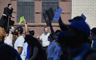 Illustrative: Members of the Orthodox Jewish community watch as protesters walk through the Brooklyn borough on June 3, 2020, during a 'Breonna Taylor and Black Lives Matter' protest in New York City, after the recent death in Minneapolis police custody of George Floyd. (Photo by Angela Weiss / AFP via Getty Images/ via JTA)