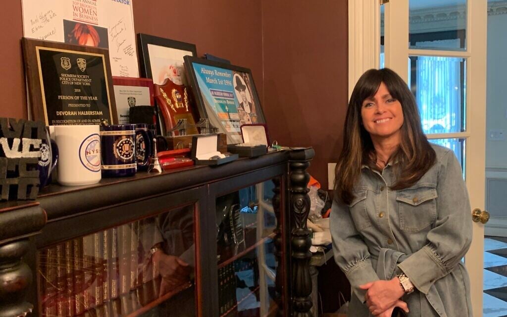 Devorah Halberstam in front of the many commendations and awards she’s received from local, state and federal law enforcement. (Cathryn J. Prince/Times of Israel)