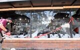 Workers repair a damaged storefront on Fairfax Avenue on May 31, 2020 in Los Angeles, California. (Valerie Macon/AFP)