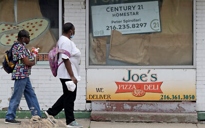 Two women walk past a closed pizza deli in Cleveland, Ohio, June 4, 2020. (AP/Tony Dejak)