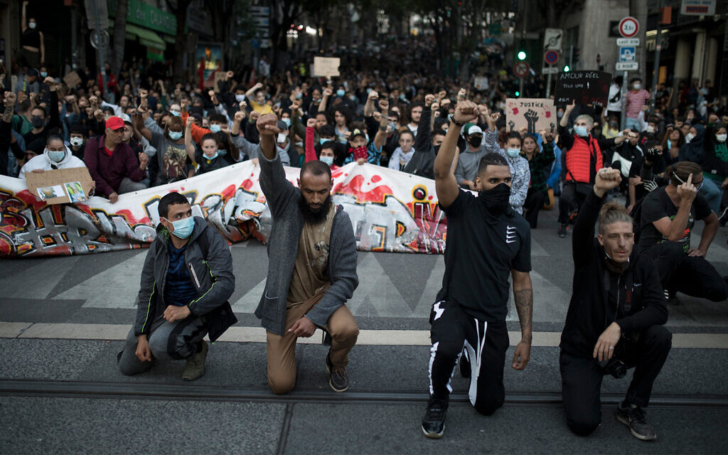 Protesters raise their fists and kneel in front of French riot police during a march against police brutality and racism in Marseille, France, June 13, 2020. (AP/Daniel Cole) Protesters raise their fists and kneel in front of French riot police during a march against police brutality and racism in Marseille, France, June 13, 2020. (AP/Daniel Cole)