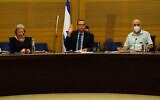 The Knesset's Foreign Affairs and Defense Committee chairman Zvi Hauser (center) votes on a bill that would allow the Shin Bet to use tracking technology to identify those exposed to the coronavirus, on June 30, 2020. (Adena Welman/Knesset)