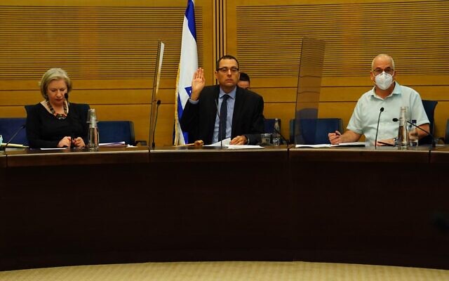 The Knesset's Foreign Affairs and Defense Committee chairman Zvi Hauser (center) votes on a bill that would allow the Shin Bet to use tracking technology to identify those exposed to the coronavirus, on June 30, 2020. (Adena Welman/Knesset) The Knesset's Foreign Affairs and Defense Committee chairman Zvi Hauser (center) votes on a bill that would allow the Shin Bet to use tracking technology to identify those exposed to the coronavirus, on June 30, 2020. (Adena Welman/Knesset)