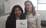 Vicly Tzur, left holds her writ of divorce with Tamar Oderberg of Yad La’isha, after a 14-year battle to obtain a get from her husband, undated. (Courtesy of Ohr Torah Stone via JTA)