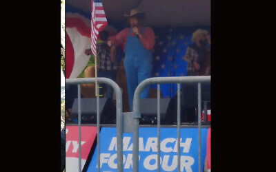 Comedian Sacha Baron Cohen performs a song with racist and conspiracy theory-laden lyrics at a far-right rally in Olympia, Washington, June 27, 2020. (Screenshot from YouTube)