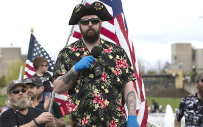 Matt Marshall of the right-wing group Washington State Three Percent (3%), and clad in the Boogaloo uniform of a Hawaiian shirt, speaks at a 'Hazardous Liberty! Defend the Constitution!' rally to protest the stay-at-home order, at the Capitol building in Olympia, Washington on April 19, 2020. (Karen Ducey/Getty Images via JTA)