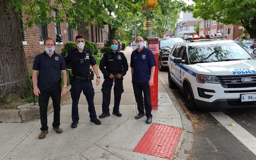 Executive coordinator for the Flatbush Shomrim Safety Patrol Bob Moskovitz, left, stands with NYPD officers in Flatbush, Brooklyn. (Courtesy)