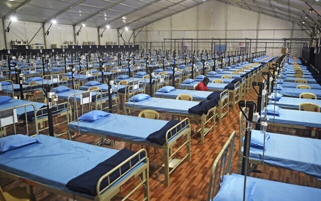 A man sits next to beds at a newly built hospital to treat Covid-19 coronavirus patients at the Mahalaxmi Racecourse, in Mumbai on July 7, 2020. (Punit PARANJPE / AFP)