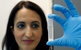 Professor Hadas Mamane holds a tube containing ethanol made from waste at her laboratory in Tel Aviv University on July 8, 2020. (JACK GUEZ/AFP)