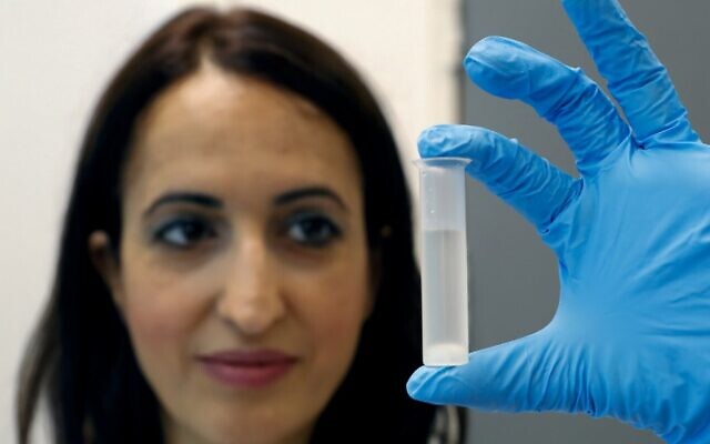 Professor Hadas Mamane holds a tube containing ethanol made from waste at her laboratory in Tel Aviv University on July 8, 2020. (JACK GUEZ/AFP) Professor Hadas Mamane holds a tube containing ethanol made from waste at her laboratory in Tel Aviv University on July 8, 2020. (JACK GUEZ/AFP)