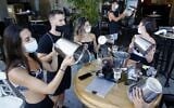 Illustrative: Mask-clad Israeli restaurant owners and others protest against lockdown measures in Tel Aviv on July 17, 2020. (JACK GUEZ / AFP)
