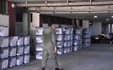 A Syrian policeman walks past ballot boxes, ahead of handing them over to the police to deliver them to polling stations on the eve of the parliamentary elections, in the Syrian city of Aleppo on July 18, 2020 (AFP)
