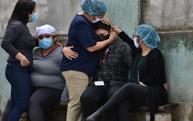 Relatives and friends of Honduran journalist David Romero, the head of Globo radio and TV station who was sentenced in 2019 to nearly 11 years in prison for defamation, cry after he died of complications from COVID-19 during the novel coronavirus pandemic, in Tegucigalpa, on July 18, 2020. (Orlando SIERRA / AFP) Relatives and friends of Honduran journalist David Romero, the head of Globo radio and TV station who was sentenced in 2019 to nearly 11 years in prison for defamation, cry after he died of complications from COVID-19 during the novel coronavirus pandemic, in Tegucigalpa, on July 18, 2020. (Orlando SIERRA / AFP)