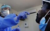 A medic collects a swab sample from a man at a coronavirus testing facility in Or Yehuda, on July 22, 2020. (Jack Guez/ AFP)