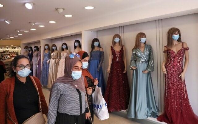 Palestinian women wearing protective masks amid the COVID-19 pandemic, shop at a clothing store as Muslims prepare for the Eid al-Adha feast, in the West Bank city of Hebron, on July 27, 2020. (HAZEM BADER / AFP) Palestinian women wearing protective masks amid the COVID-19 pandemic, shop at a clothing store as Muslims prepare for the Eid al-Adha feast, in the West Bank city of Hebron, on July 27, 2020. (HAZEM BADER / AFP)
