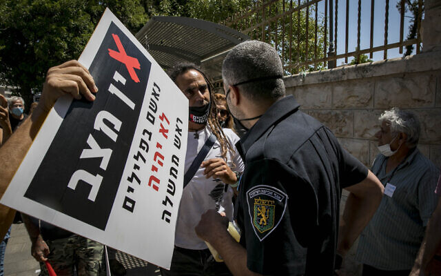 Jerusalem municipality inspector speaks to a demonstrator near Prime Minister Benjamin Netanyahu's official residence in Jerusalem on July 13 2020 (Olivier Fitoussi/Flash90) Jerusalem municipality inspector speaks to a demonstrator near Prime Minister Benjamin Netanyahu's official residence in Jerusalem on July 13 2020 (Olivier Fitoussi/Flash90)