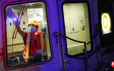 A contractor cleans a subway car at the 96th Street station to control the spread of COVID-19, Thursday, July 2, 2020, in New York. Mass transit systems around the world have taken unprecedented — and expensive — steps to curb the spread of the coronavirus, including shutting down New York subways overnight and testing powerful ultraviolet lamps to disinfect seats, poles and floors. (AP Photo/John Minchillo)