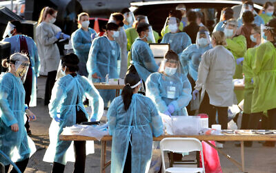 Illustrative; Medical personnel prepare to test hundreds of people lined up in vehicles in Phoenix's western neighborhood of Maryvale for free COVID-19 tests organized by Equality Health Foundation, June 27, 2020. (AP Photo/Matt York, File)