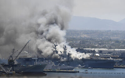 Smoke rises from the USS Bonhomme Richard at Naval Base San Diego Sunday, July 12, 2020, in San Diego after an explosion and fire Sunday on board the ship at Naval Base San Diego. (AP Photo/Denis Poroy)