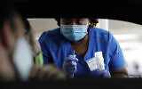 Healthcare worker Rahaana Smith instructs passengers how to provide their coronavirus test sample, on Friday, July 24, 2020, at a drive-thru coronavirus testing site in Miami. (AP/Wilfredo Lee)